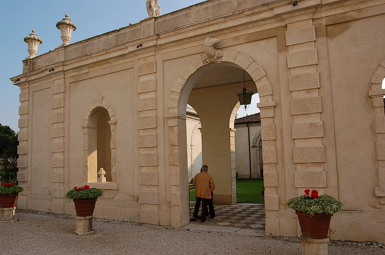 A pale stone arched gateway and outbuilding in the grounds of Villa Cordellina Lombardi